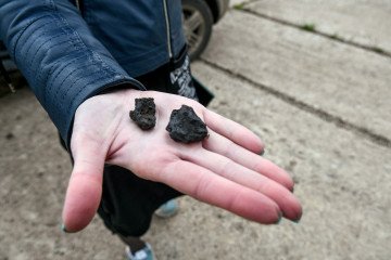 A woman holds two artefacts from the closed manganese ore mine in Stepnohirsk, Zaporizhzhia Region, southeastern Ukraine. (Source: Getty Images)