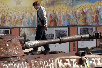 A young man walks on a destroyed Russian self-propelled howitzer displayed in the Mykhailivska Square in Kyiv on October 1, 2024. Illustrative photo. (Source: Getty Images)