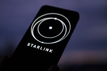 The Starlink logo is displayed on a mobile phone. Illustrative image. (Source: Getty Images)