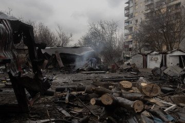 A man looks through debris at the site of a recent Russian air attack in front of a damaged residential apartment building in Zaporizhzhia on March 18, 2026. (Source: Getty Images)