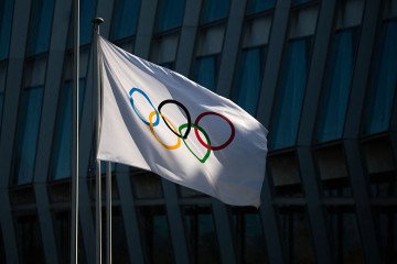 A picture taken on March 8, 2021 in Lausanne shows the Olympic flag floating next to the headquarters of the International Olympic Committee (IOC). (Source: Getty Images) A picture taken on March 8, 2021 in Lausanne shows the Olympic flag floating next to the headquarters of the International Olympic Committee (IOC). (Source: Getty Images)