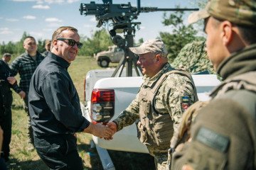 El Ministro de Defensa de Alemania junto a oficiales ucranianos frente a una batería de defensa aérea y los restos de una central eléctrica dañada en Kyiv.