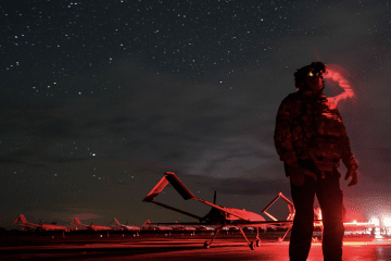 A Ukrainian service member stands beside long-range drones before a nighttime launch during Russia’s full-scale war in Ukraine. (Source: Evgeniy Maloletka)