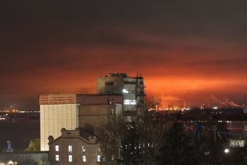 An intense fire glows on the horizon after a drone strike, with flames and smoke illuminating the night sky. (Source: Russian media)