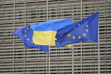 EU and Ukrainian flags fly in the wind in front of the Berlaymont, the EU Commission headquarters for the 4th anniversary of the full-scale invasion of Ukraine by Russia, on February 23, 2025, in Brussels, Belgium. (Source: Getty Images)