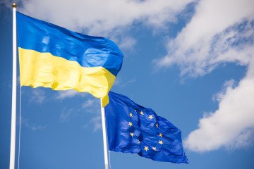 Flags of Ukraine and European Union (EU) with blue sky background. Illustrative photo. (Getty Images)