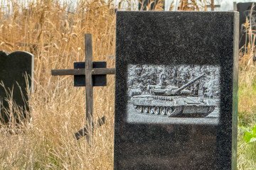 Black granite tombstone with an engraved russian tank in a cemetery, Donetsk region, Mariupol, Ukraine, on November 24, 2025.