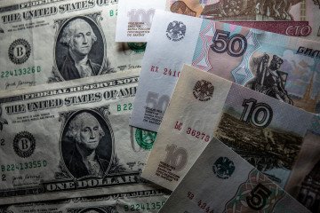 Russia Sets New Military Spending Record at $142.25B as War Costs Climb to $20.9M Per Hour for Moscow In this photo illustration, Russian rouble notes are seen besides one Dollar bill notes on January 11, 2025 in Bath, England. Illustrative photo. (Source: Getty Images)