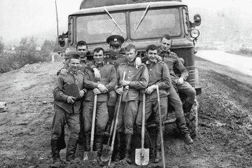 Soviet military construction battalion (“stroybat”) conscripts pose with shovels in front of a military truck during road construction in the Soviet Union. (Photo: open source)