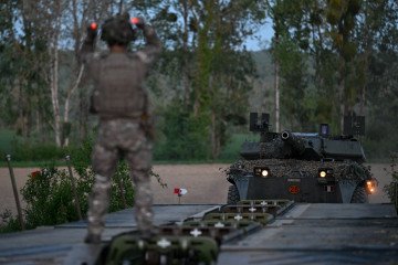 A soldier of the 3rd Engineer Regiment directs an Italian Centauro tank to cross the Aube river during the ORION 26 military exercises in Radonvilliers, north-eastern France, on April 22, 2026. (Source: Getty Images)