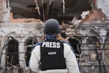 A journalist looks at a damaged house after a Russian drone attack on January 22, 2025 in Sumy, Ukraine. (Source: Getty Images)