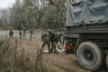 Polish Army soldiers unload razor wire from a military truck while constructing a fence along the Polish border, with the Russian enclave of Kaliningrad, near Zerdziny, Poland, on November 5, 2022. (Source: Getty Images)