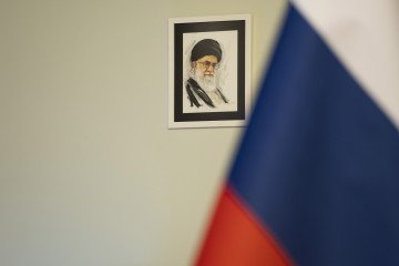 A portrait of Iran’s Supreme Leader, Ayatollah Ali Khamenei, appears next to a Russian flag before a news conference at the Vahdat Hall in downtown Tehran, Iran, on June 10, 2025. (Source: Getty Images)