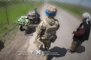 Ukrainian paratroopers help an elderly civilian flee the frontline village.
