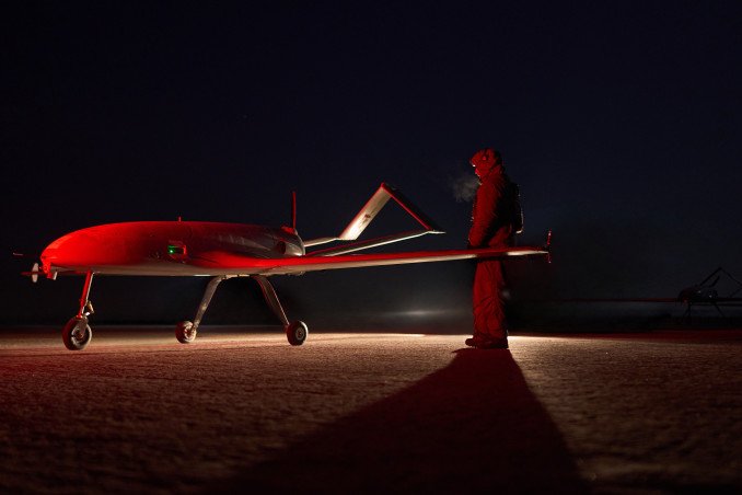 A Ukrainian servicemember stands beside a drone under red lighting. (Source: Mykyta Shandyba/UNITED24 Media)