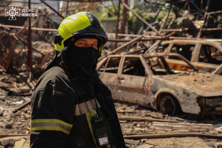 A firefighter stands amid the aftermath of a Russian overnight missile and drone attack in Kyiv's Darnytskyi district on June 28, 2026. (Source: State Emergency Service of Ukraine)