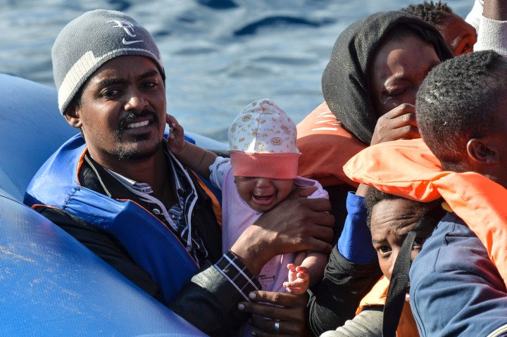 A man seated on a rubber boat holds his baby during a rescue operation of migrants by the crew of the Topaz Responder, a rescue ship run by Maltese NGO "Moas" and the Italian Red Cross. (Source: Andreas Solaro via Getty Images) A man seated on a rubber boat holds his baby during a rescue operation of migrants by the crew of the Topaz Responder, a rescue ship run by Maltese NGO "Moas" and the Italian Red Cross. (Source: Andreas Solaro via Getty Images)