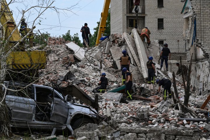 Rescuers clear the scene after a Russian missile strike destroyed a five-story residential building, killing 48 people and injuring 25, on July 9, 2022 in Chasiv Yar, Donetsk Ukraine. (Photo by Miguel Medina/AFP via Getty Images)