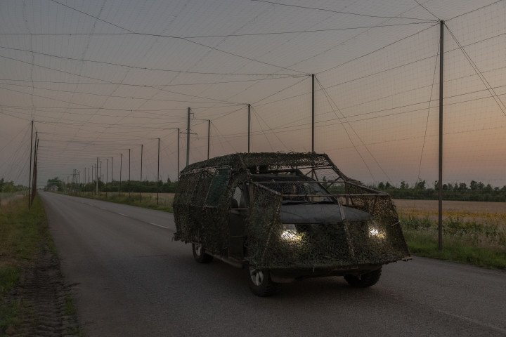 Ukrainian military vehicle drives under anti-drone nets installed along a road in Donetsk region. (Source: Getty Images)