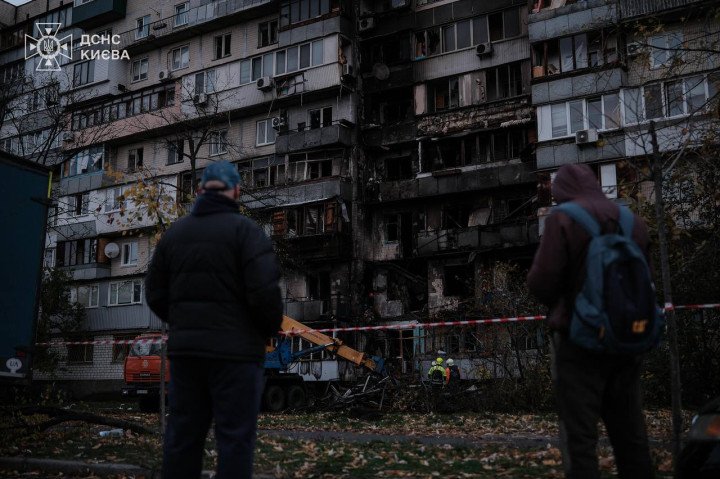 Residents observe the aftermath of a drone strike on a Kyiv apartment building, with visible fire damage and emergency crews on site. (Source: DSNS Kyiv)