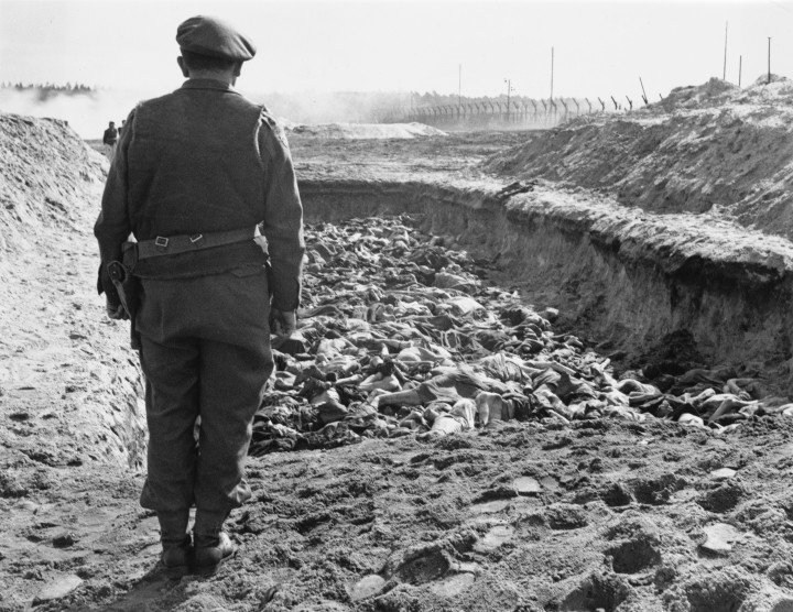 El reverendo Leslie Hardman (1913-2008), capellán judío principal del 2.º Ejército Británico, se encuentra junto a los cuerpos de los prisioneros fallecidos que yacen en la fosa común número 2, listos para ser enterrados tras la liberación del campo de concentración de Bergen-Belsen por unidades de la 11.ª División Blindada británica el 23 de abril de 1945 en Bergen-Belsen, cerca de Celle, Baja Sajonia, Alemania. (Foto de Harry Oakes/Unidad Cinematográfica y Fotográfica del Ejército Británico/Archivo Keystone/Hulton/Getty Images).