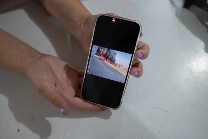 Oleksandra, que trabaja cerca del concesionario de automóviles, muestra una foto en su teléfono que tomó tras el ataque ruso con drones FPV el 9 de julio de 2025, en Dobropillia. La imagen capta coches ardiendo a causa del ataque. Oleksandra expresó su temor por ir y volver del trabajo, tras haber visto recientemente un dron FPV ruso en su calle. 12 de julio de 2025, Dobropillia, región de Donetsk, Ucrania. Fotografía: Kseniia Tomchyk Oleksandra, que trabaja cerca del concesionario de automóviles, muestra una foto en su teléfono que tomó tras el ataque ruso con drones FPV el 9 de julio de 2025, en Dobropillia. La imagen capta coches ardiendo a causa del ataque. Oleksandra expresó su temor por ir y volver del trabajo, tras haber visto recientemente un dron FPV ruso en su calle. 12 de julio de 2025, Dobropillia, región de Donetsk, Ucrania. Fotografía: Kseniia Tomchyk