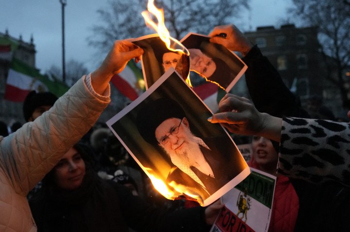 Protestors burn images of Ayatollah Ali Khamenei during a rally held in Solidarity with Iran's Uprising, organised by The national Council of Resistance of Iran, on Whitehall in central London on January 11, 2026, to protest against the Iranian regime's crackdown on internet access and "recognise their right to self-defence against the regime's forces". (Photo by CARLOS JASSO / AFP via Getty Images)