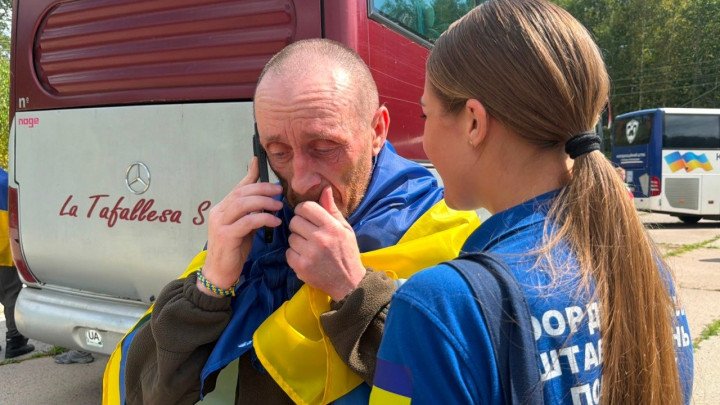 Un miembro de las fuerzas armadas ucranianas habla por teléfono móvil poco después de ser liberado del cautiverio ruso durante el intercambio de prisioneros.