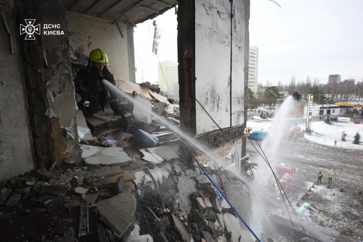 Firefighters respond to a strike on a multi-story building, working to suppress flames from within a partially collapsed upper floor. (Source: State Emergency Service of Ukraine)