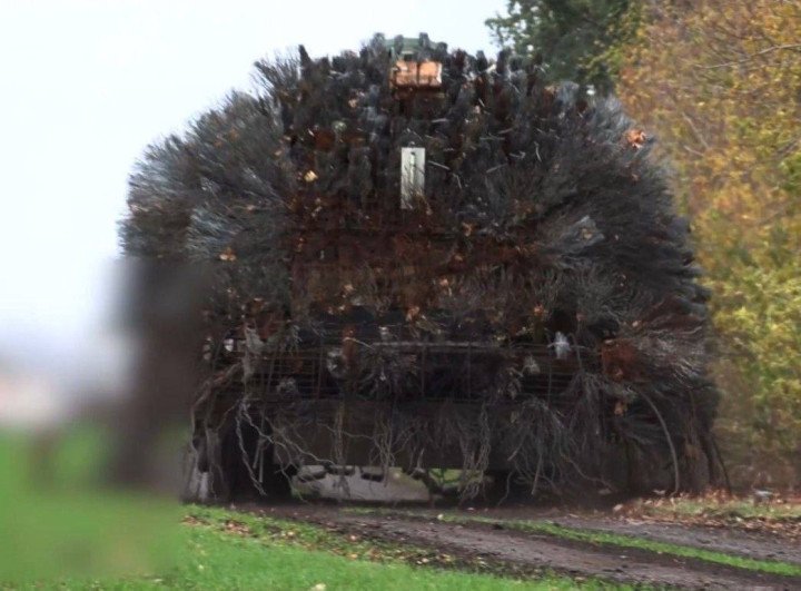 Vista trasera de un tanque ruso envuelto en densas capas de alambre metálico, que recuerda a un "erizo de acero", diseñado para enredar y desviar ataques con drones. (Fuente: Vodohrai)
