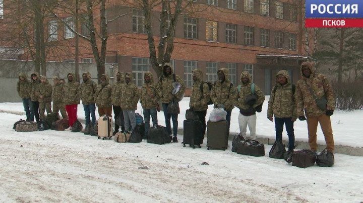 Una imagen supuestamente tomada de la televisión estatal rusa muestra una fila de hombres esperando a ser transportados a un entrenamiento básico, antes de ser finalmente desplegados para luchar en Ucrania. El grupo parece incluir reclutas rusos y africanos. Una imagen supuestamente tomada de la televisión estatal rusa muestra una fila de hombres esperando a ser transportados a un entrenamiento básico, antes de ser finalmente desplegados para luchar en Ucrania. El grupo parece incluir reclutas rusos y africanos.