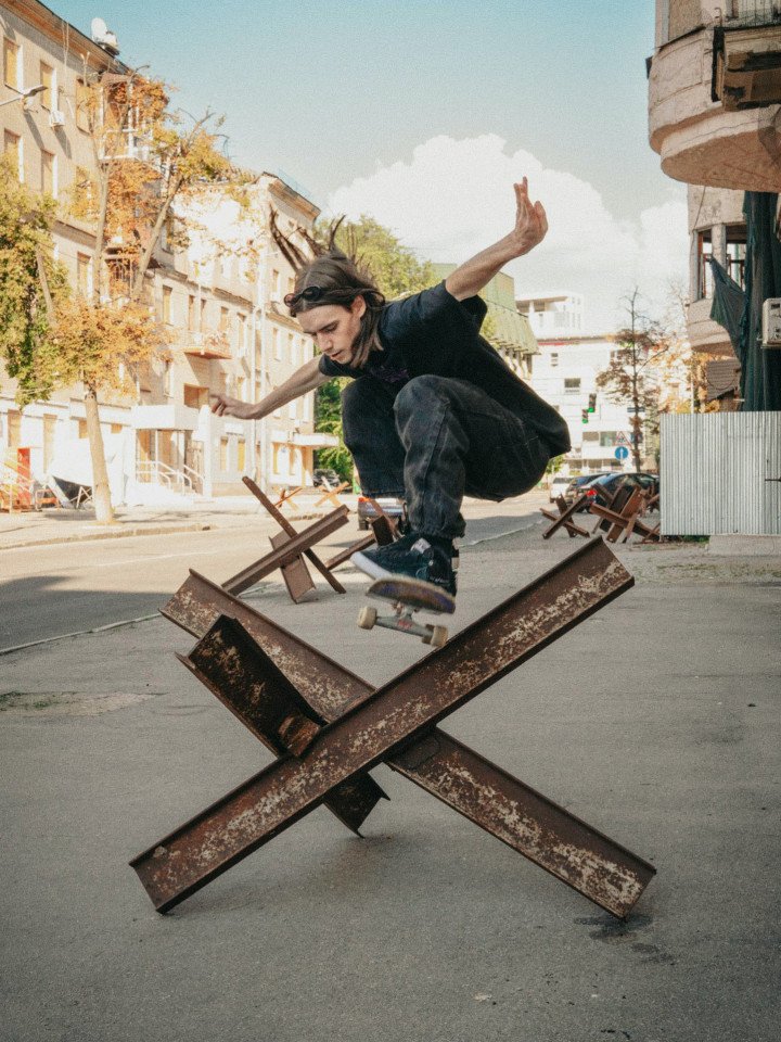 A skater jumps over an anti-tank hedgehog placed on a street in Kharkiv. (Photo: Hironori Kodama)