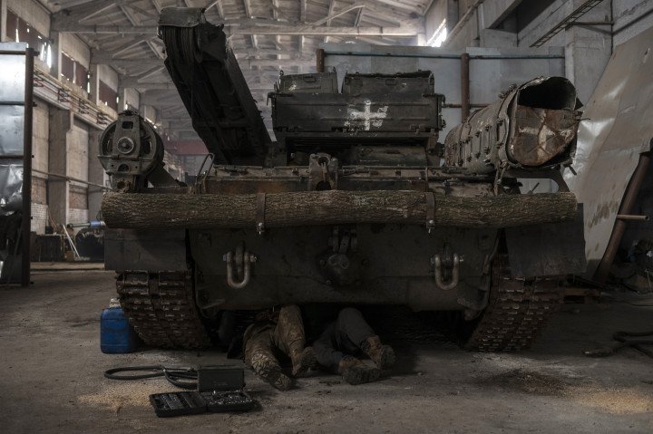 Ukrainian mechanics service a tank at a military repair workshop in Donetsk region, December 24, 2023. (Source: Getty Images)