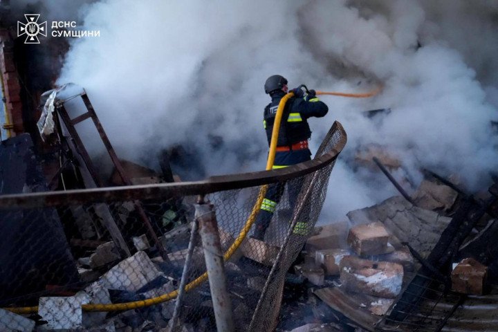 A rescuer extinguishes flames at a destroyed building after Russian attacks in the Sumy region on March 14, 2026. (Source: State Emergency Service of Ukraine in the Sumy region)