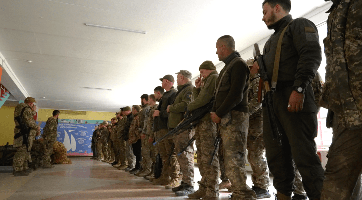 A long line of newly enlisted civilian recruits undergoes a roll call under Commander Validol during the early months of Russia’s full-scale invasion. (Photo: Xackery Irving) 