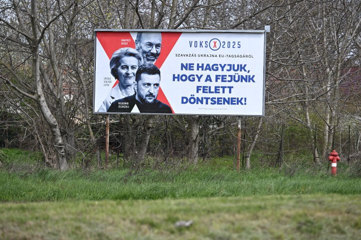 A political campaign poster in Szekesfehervar, Hungary, captured on April 7, 2025, features (back to front) EPP President and European Parliament EPP Group Leader Manfred Weber, European Commission President Ursula von der Leyen, and Ukrainian President Volodymyr Zelensky. The poster reads, “Voting 2025: about Vote for Ukraine in the EU membership, Don’t let them decide for us!” (Source: Getty Images) A political campaign poster in Szekesfehervar, Hungary, captured on April 7, 2025, features (back to front) EPP President and European Parliament EPP Group Leader Manfred Weber, European Commission President Ursula von der Leyen, and Ukrainian President Volodymyr Zelensky. The poster reads, “Voting 2025: about Vote for Ukraine in the EU membership, Don’t let them decide for us!” (Source: Getty Images)