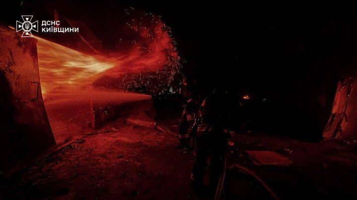 Las llamas estallan desde una estructura impactada durante un ataque con drones o misiles en la región de Kyiv mientras los bomberos intentan contener el incendio. (Fuente: Servicios de Emergencia de la Región de Kyiv)