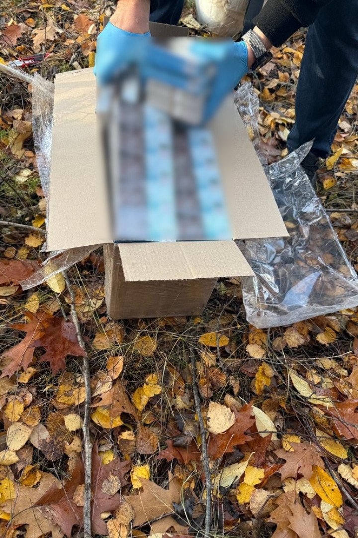 Polish Border Guard personnel examine contraband cigarettes seized from the intercepted drone, showing packs with Belarusian excise stamps. (Source: Polish Border Guard) Polish Border Guard personnel examine contraband cigarettes seized from the intercepted drone, showing packs with Belarusian excise stamps. (Source: Polish Border Guard)