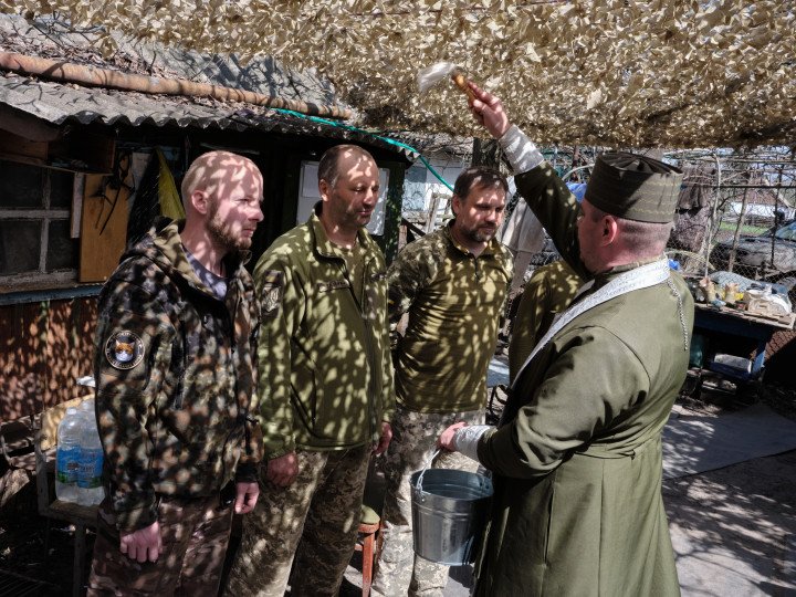 Father Mykola blesses the soldiers who are preparing to take up positions. Photo: Joshua Olley Father Mykola blesses the soldiers who are preparing to take up positions. Photo: Joshua Olley