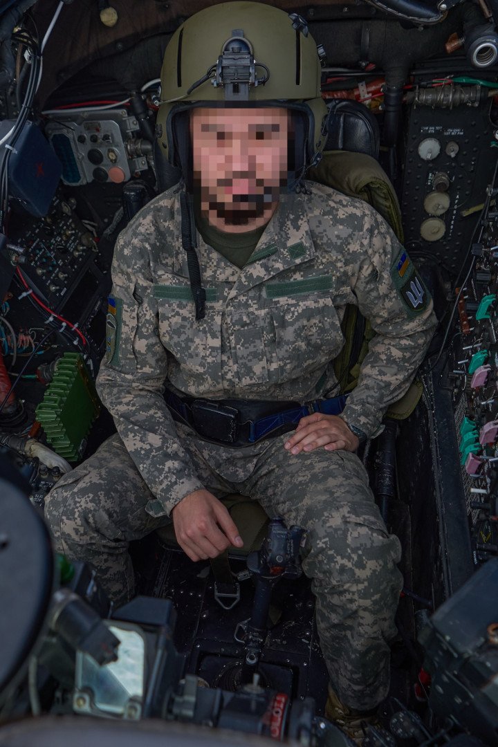 A Ukrainian Mi-24 helicopter pilot seated in the cockpit of a Mi-24, fully equipped and ready for takeoff. A Ukrainian Mi-24 helicopter pilot seated in the cockpit of a Mi-24, fully equipped and ready for takeoff.