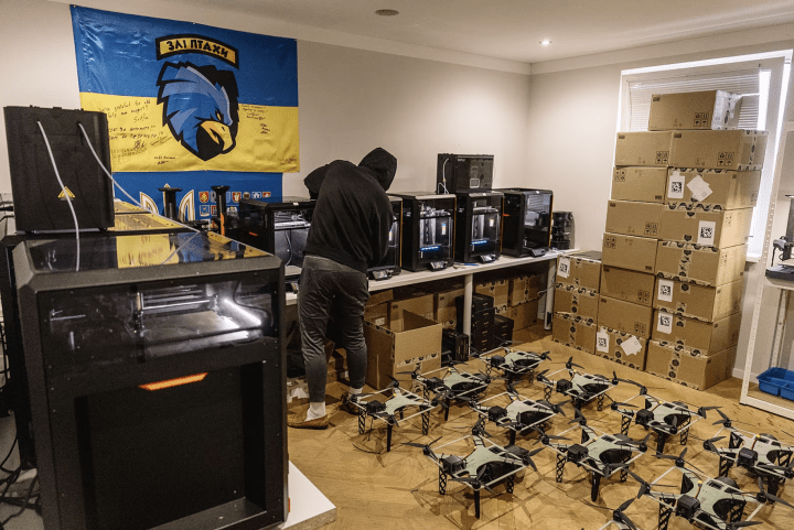 Volunteers assemble FPV drones at a production site, where 3D printers and boxed components support small-scale manufacturing. (Photo: iDNES) Volunteers assemble FPV drones at a production site, where 3D printers and boxed components support small-scale manufacturing. (Photo: iDNES)
