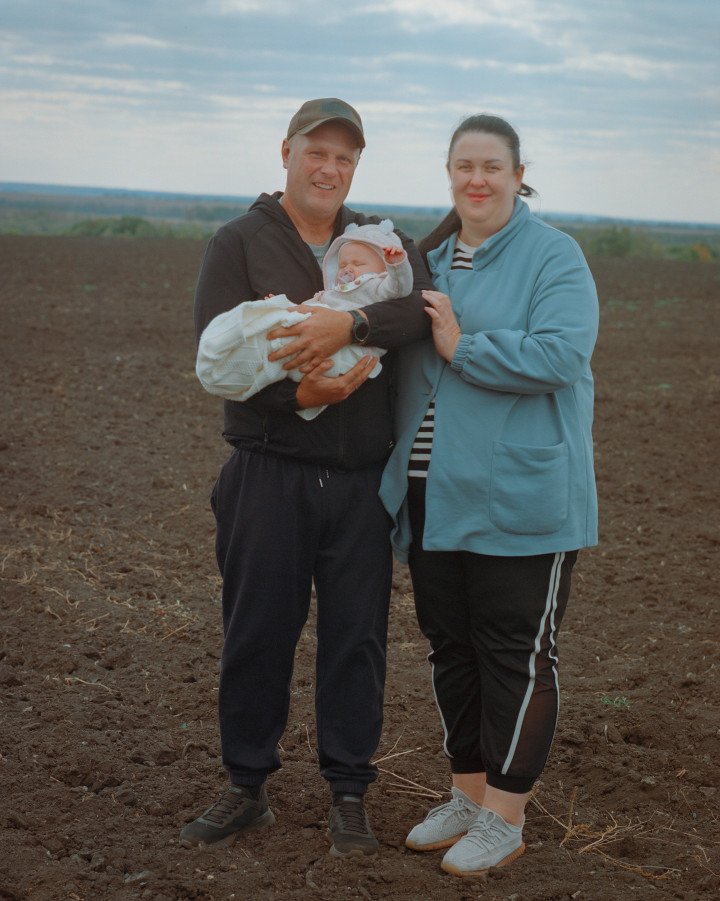 Maryna, her husband, and their young daughter on their plot in Andriivka, Ukraine. October, 2025. Photo by Joshua Olley/UNITED24 Media.