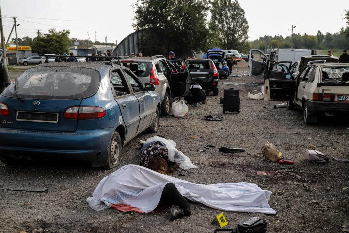 Bodies of civilians killed by a missile strike lay on a road near Zaporizhzhia on September 30, 2022, amid the Russian invasion of Ukraine. (Photo by KATERYNA KLOCHKO/AFP via Getty Images)