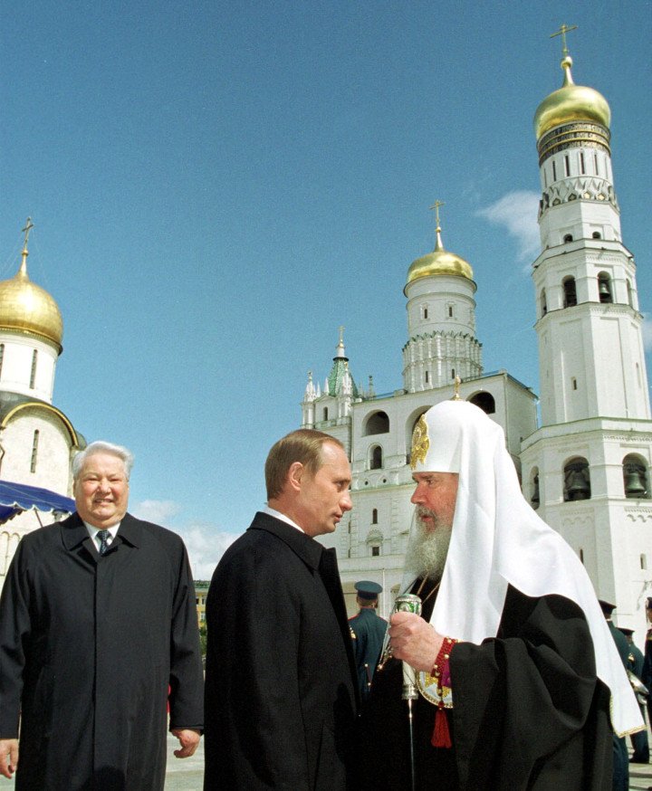 Russian leader Vladimir Putin (C) talks to Russian Orthodox Church Patriarch Alexy II (R), 07 May 2000 in Moscow. (Photo: AFP via Getty Images)