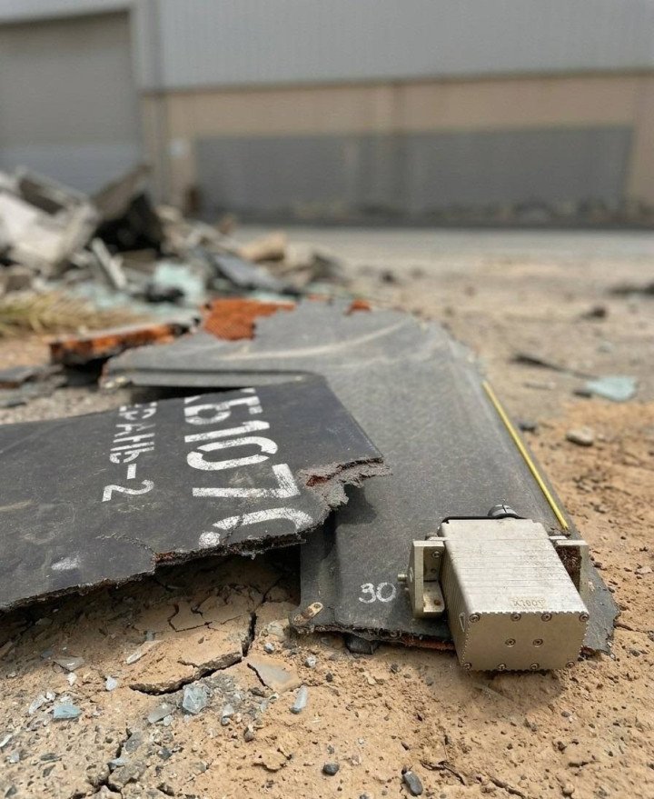 Fragments of a loitering munition bearing the Russian “Geran-2” marking lie on the ground after being intercepted in Dubai, with debris scattered across the impact site. (Source: Open source)