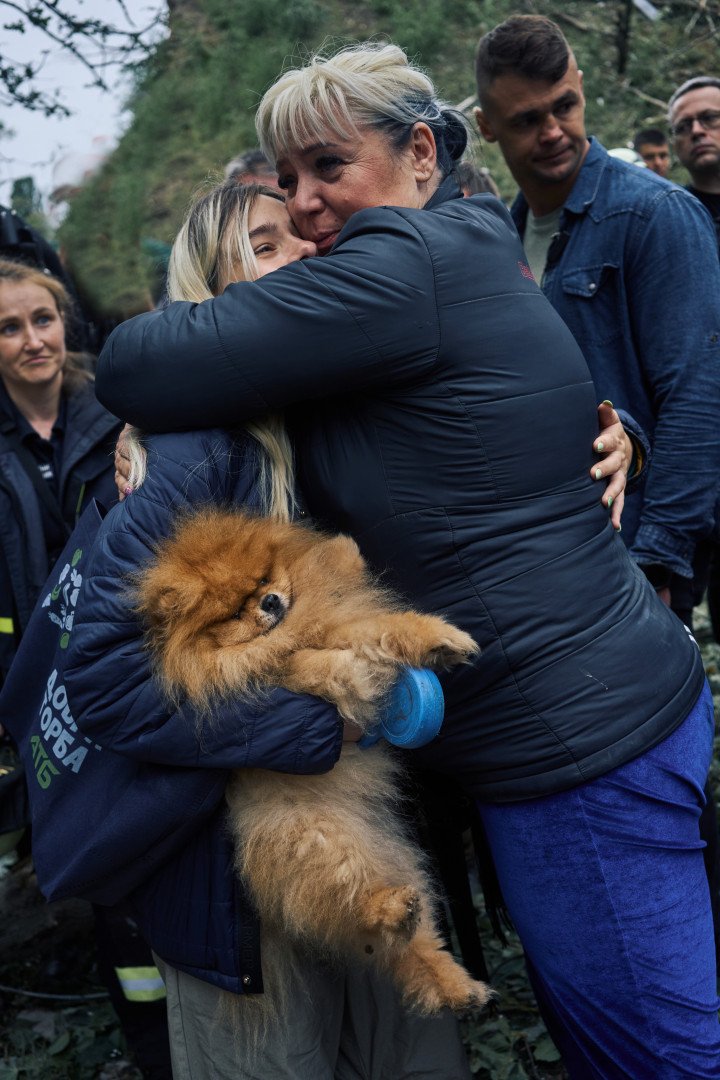 A woman embraces a young girl with her dog. The Russian attack left dozens injured and entire families displaced in the Sviatoshynskyi district. Kyiv, Ukraine. July 31, 2025. Photo by Josh Olley/UNITED24 Media