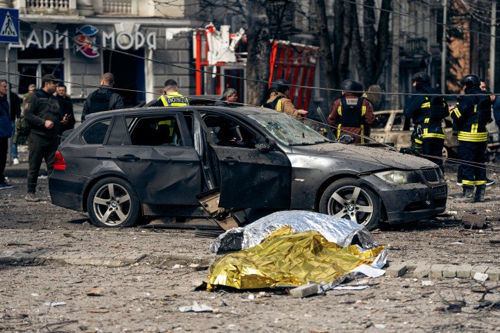 SUMY, UKRAINE - APRIL 13: Bodies of people killed in a Russian ballistic missile strike lie covered with emergency blankets at the strike site on April 13, 2025 in Sumy, Ukraine. The death toll after Russian ballistic missiles' attack on the center of Sumy has risen to 34, including two children. At least 117 people have been injured, including 15 children. On Palm Sunday, the Russian army launched two ballistic missiles with cluster munition at the central part of the city at a time when there were many people on the streets - dozens of people were killed and injured in the city; civilian infrastructure and residential buildings were damaged or destroyed. (Photo: Oleksandr Oleksienko Getty Images)