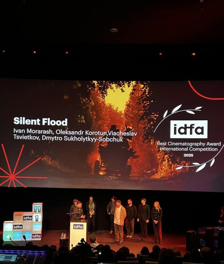Director Dmytro Sukholytkyy-Sobchuk and team accept the IDFA 2025 Best Cinematography Award on stage in Amsterdam, with the winning still from “Silent Flood” displayed behind them. Director Dmytro Sukholytkyy-Sobchuk and team accept the IDFA 2025 Best Cinematography Award on stage in Amsterdam, with the winning still from “Silent Flood” displayed behind them.