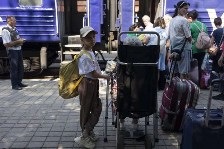 A little girl stands next to her grandmother at a railroad station in Pokrovsk, waiting for an evacuation train (Source: Oleksandr Magula via Getty Images) A little girl stands next to her grandmother at a railroad station in Pokrovsk, waiting for an evacuation train (Source: Oleksandr Magula via Getty Images)