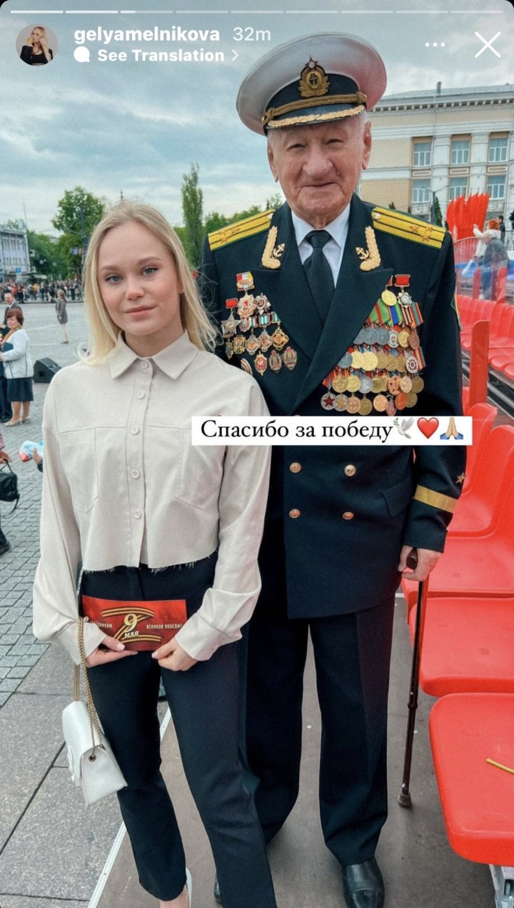 Russian gymnast Angelina Melnikova poses with a veteran while holding a Victory Day-themed card featuring a stylized Z symbol associated with Russia’s war against Ukraine. (Source: Angelina Melnikova/Instagram)